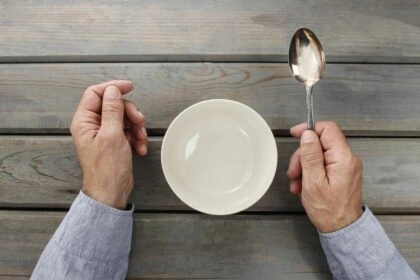 Personne devant une assiette vide entraînant un risque de dénutrition