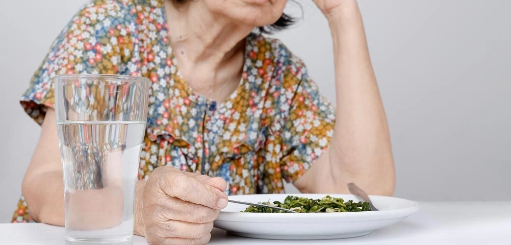 Dame âgée qui prend un repas