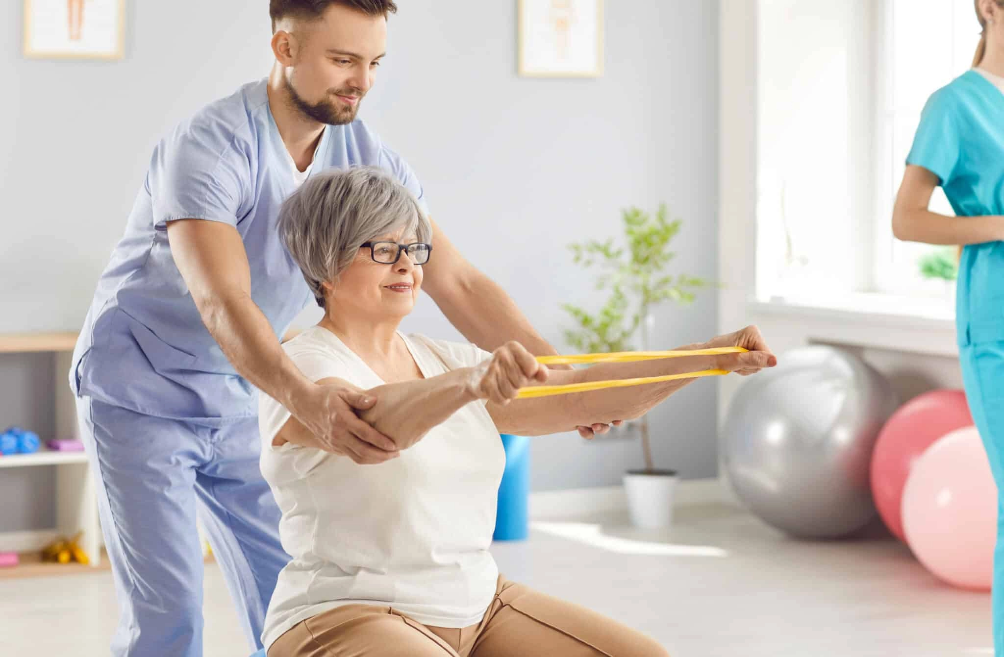 Femme senior qui fait de l'activité physique adaptée encadrée par un professionnel